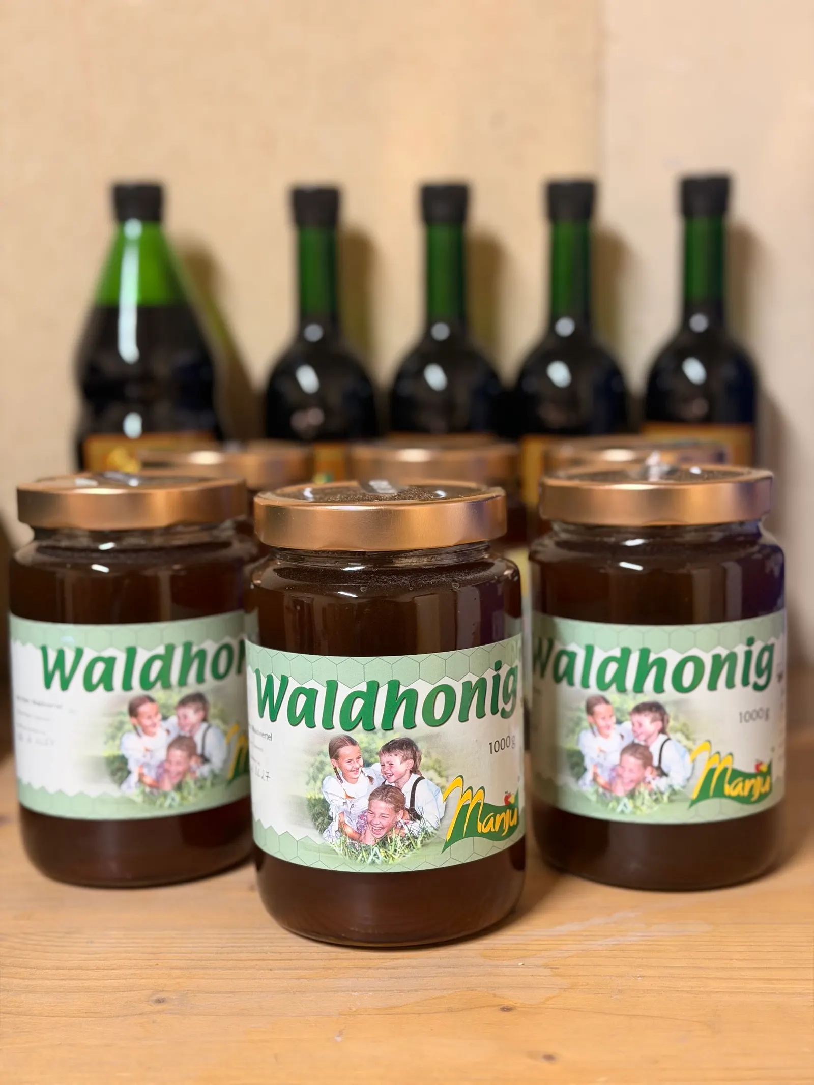 Gläser Waldhonig vor Weinflaschen